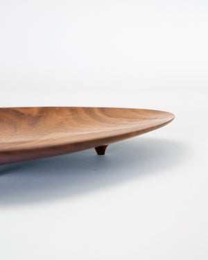 footed black walnut plate in an asymmetrical shape. Handmade by Korean artist Heum Namkung.
