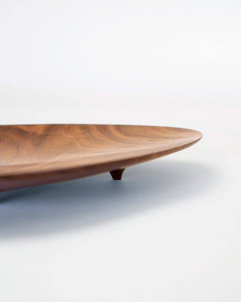 Load image into Gallery viewer, footed black walnut plate in an asymmetrical shape. Handmade by Korean artist Heum Namkung.